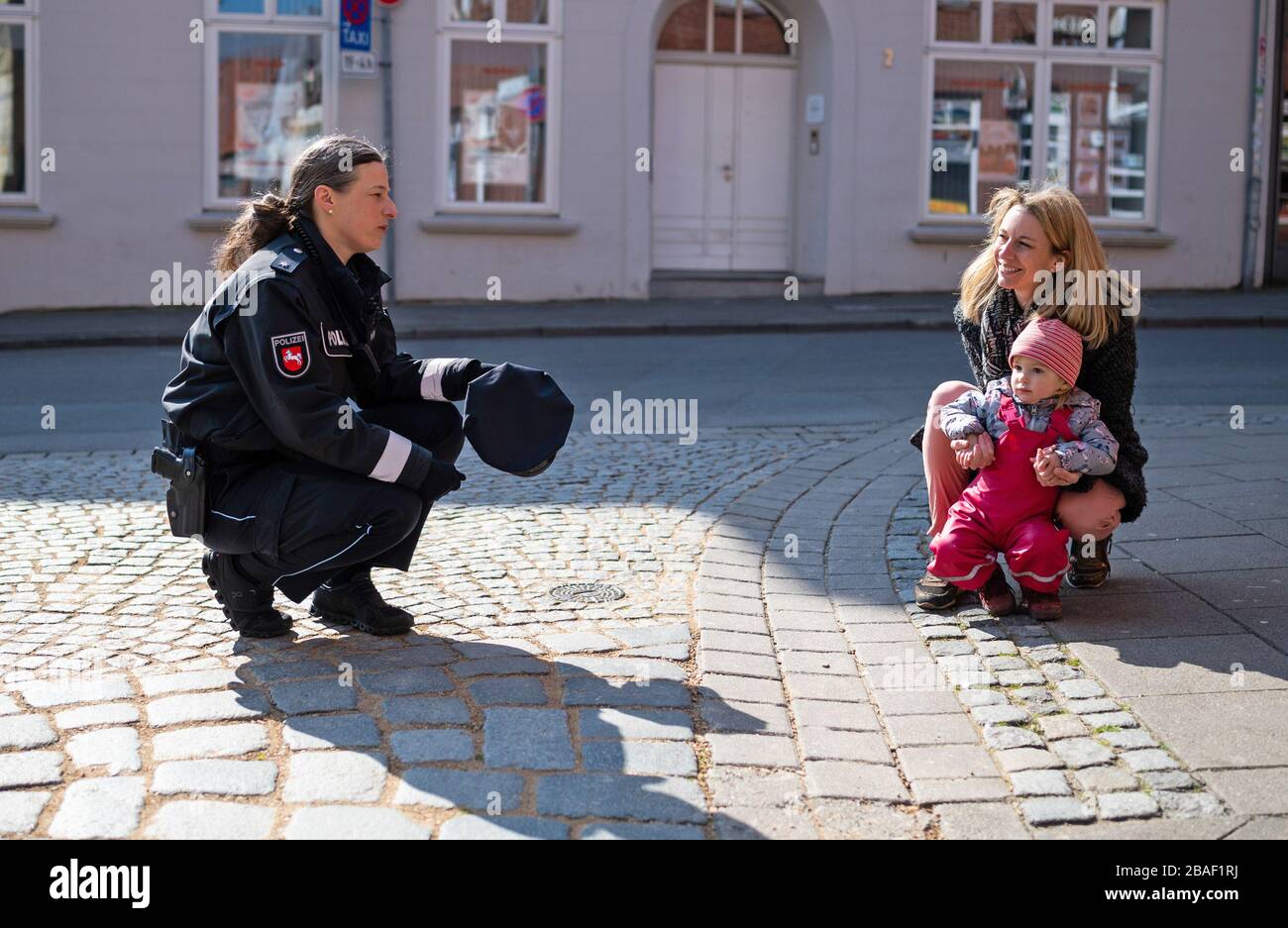 27 March 2020, Lower Saxony, Lüneburg: Nicoline Wiermann (l), contact officer of the police, talks to Levke and her mother, Heike. Among other things, the policewoman monitors compliance with the contact ban and is the contact person for citizens. Photo: Philipp Schulze/dpa Stock Photo