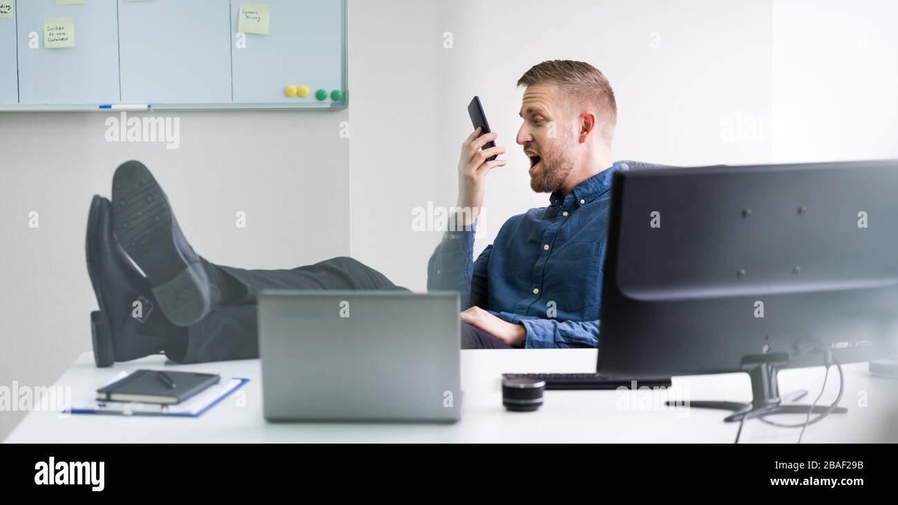 Angry Man Screaming On Phone In Office Stock Photo