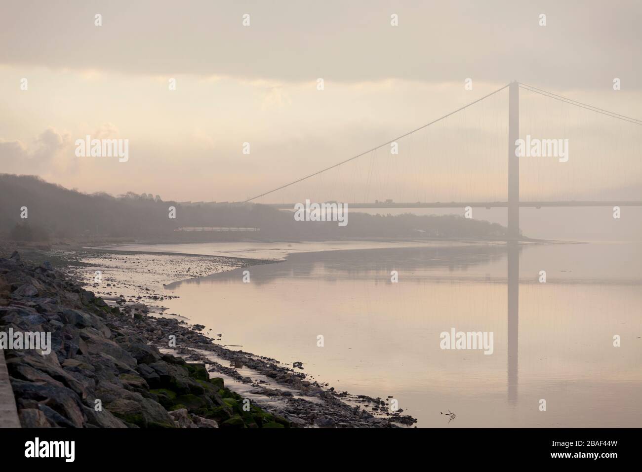 LNER High speed train passing the Humber bridge and river Humber at North Ferriby on a misty morning with a hull - Kings cross train Stock Photo