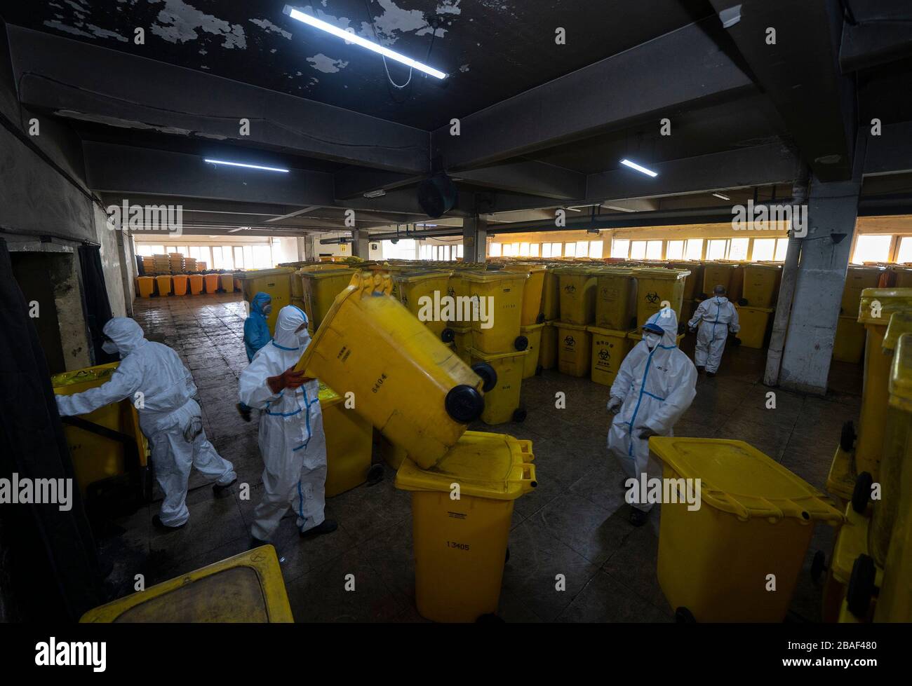 (200327) -- WUHAN, March 27, 2020 (Xinhua) -- Wang Peng (1st L) and his colleagues work at a medical waste treatment company in Wuhan, central China's Hubei Province, March 26, 2020. Wang Peng, 35, has been working for the Wuhan Hanshi Environmental Engineering Company for 9 years, where he is responsible for the disposal and incineration of medical waste.Protection against infection is a major challenge that Wang and his coworkers face, as they work 12-hour shifts to cope with the surging workload during the COVID-19 outbreak. 'I like what I'm doing,' Wang said, 'I'm not only making money for Stock Photo