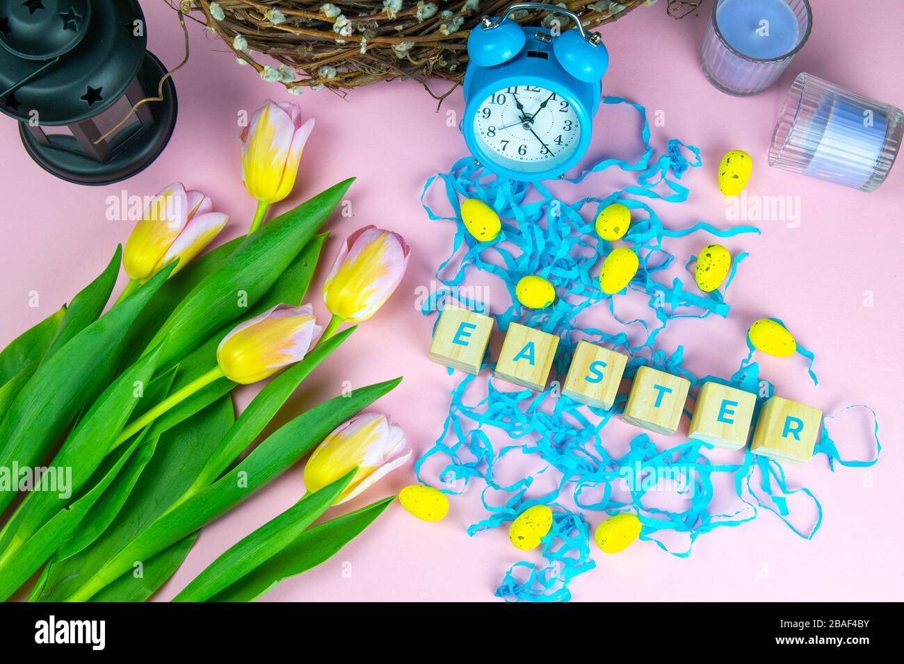 Word Easter on wooden cubes and surrounded with multiple egg decorations as a festive Easter background composition Stock Photo