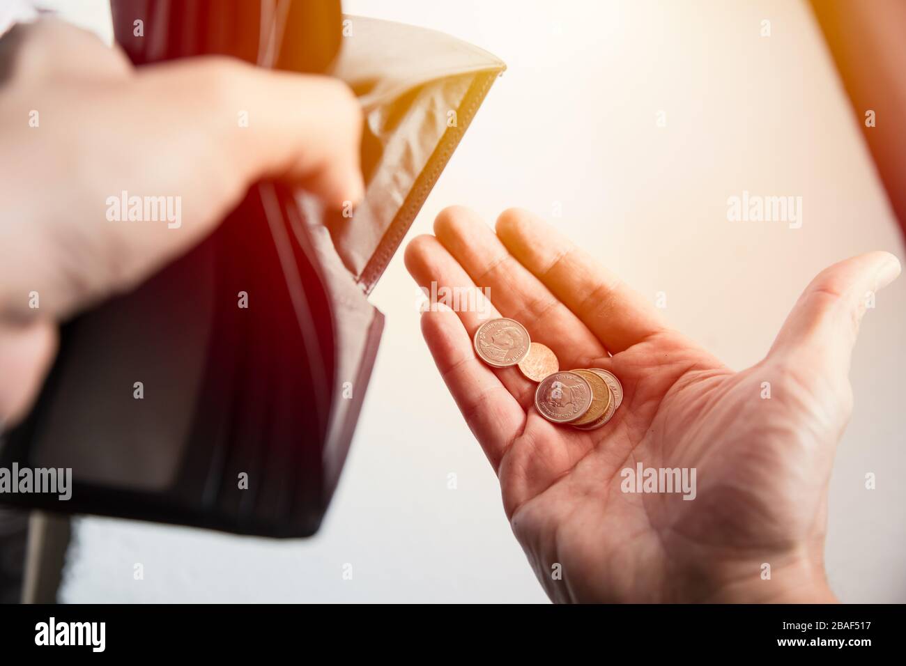 People are facing economic downturn. No money in the wallet only coins left as a poor broke man. Stock Photo