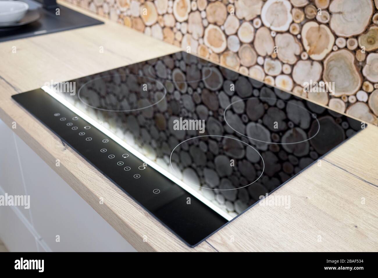rumor Western spur Modern kitchen interior with black induction stove, cooker, hob or built in  cooktop with ceramic top surface behind the countertop decorated with wall  Stock Photo - Alamy