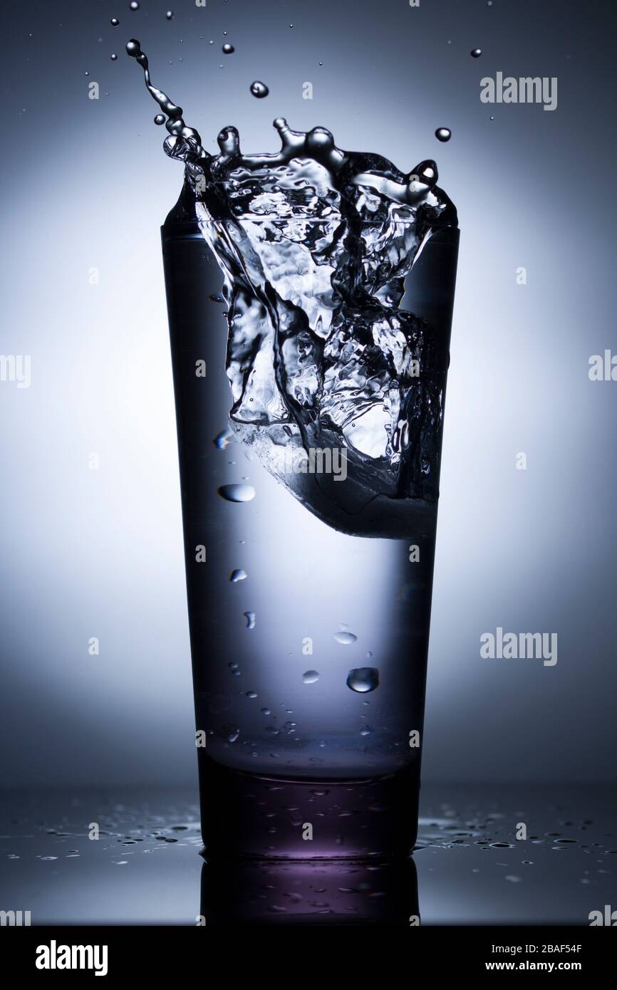 A glass of pure fresh water is poured into a glass. Close up, vertical shot Stock Photo