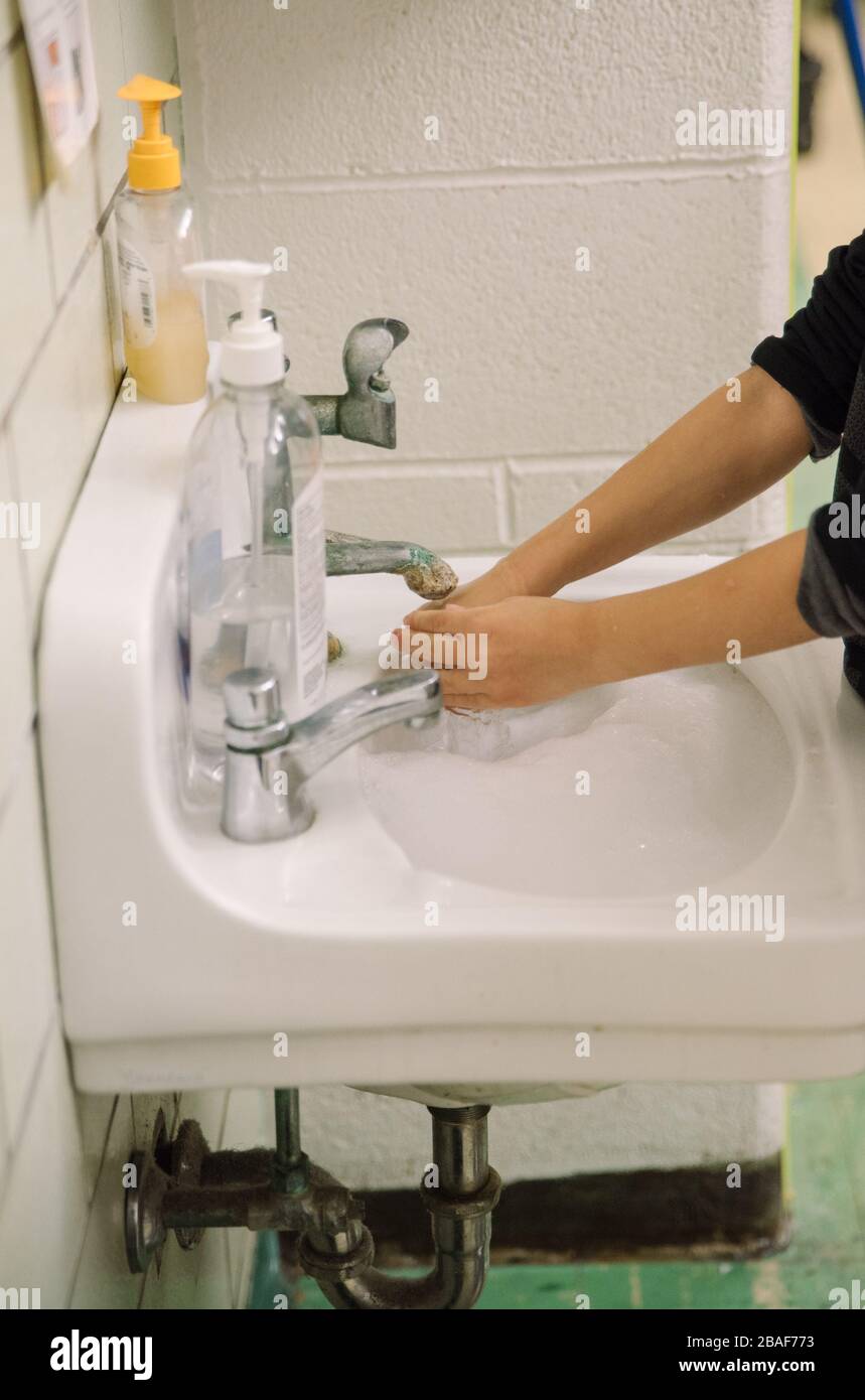 children washing hands in elementary school sink Stock Photo