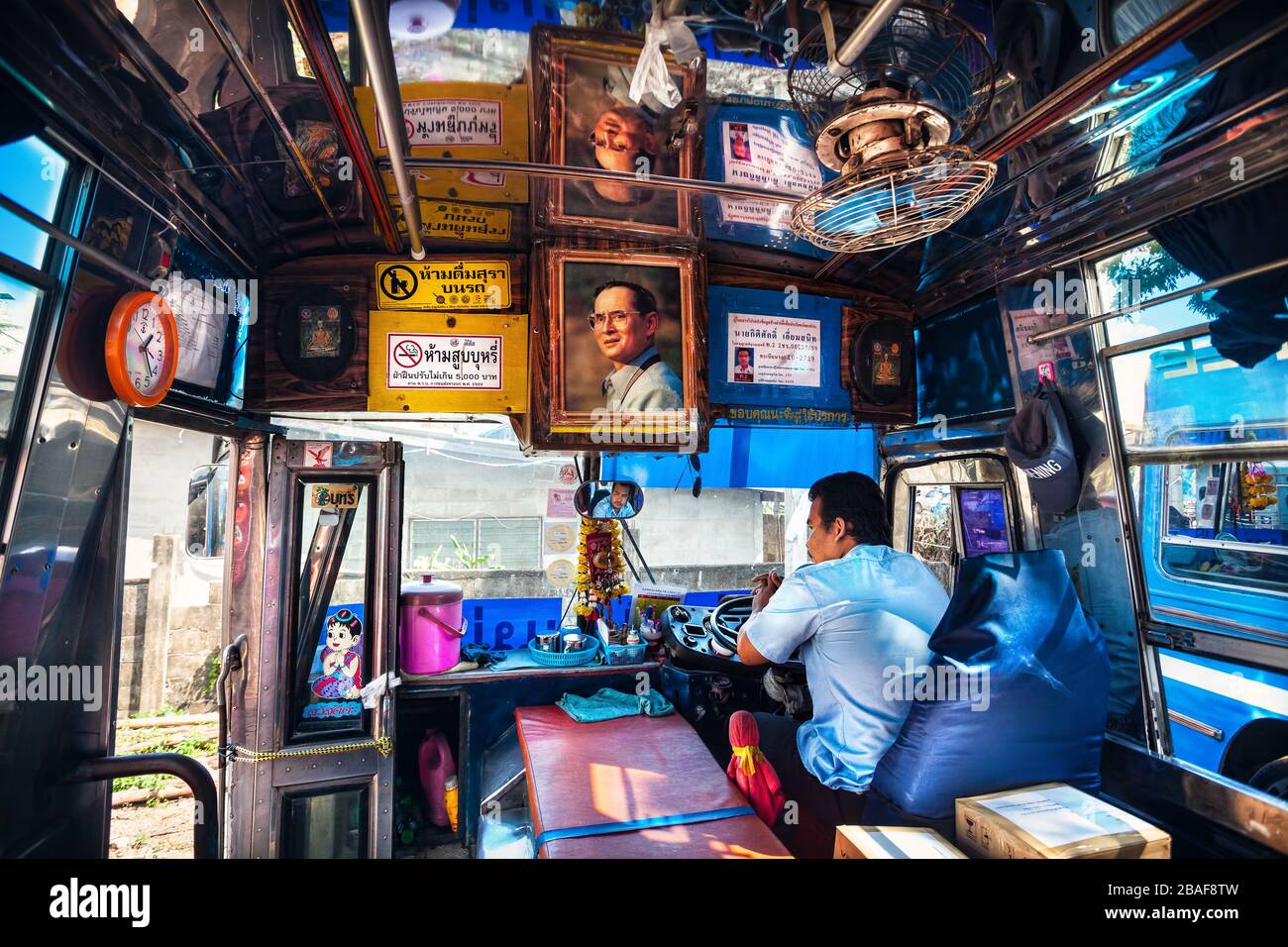 CHIANG RAI, Thailand - November 26, 2016: Cabin of public bus with portrait of King and driver waiting of departure at the station terminal Stock Photo