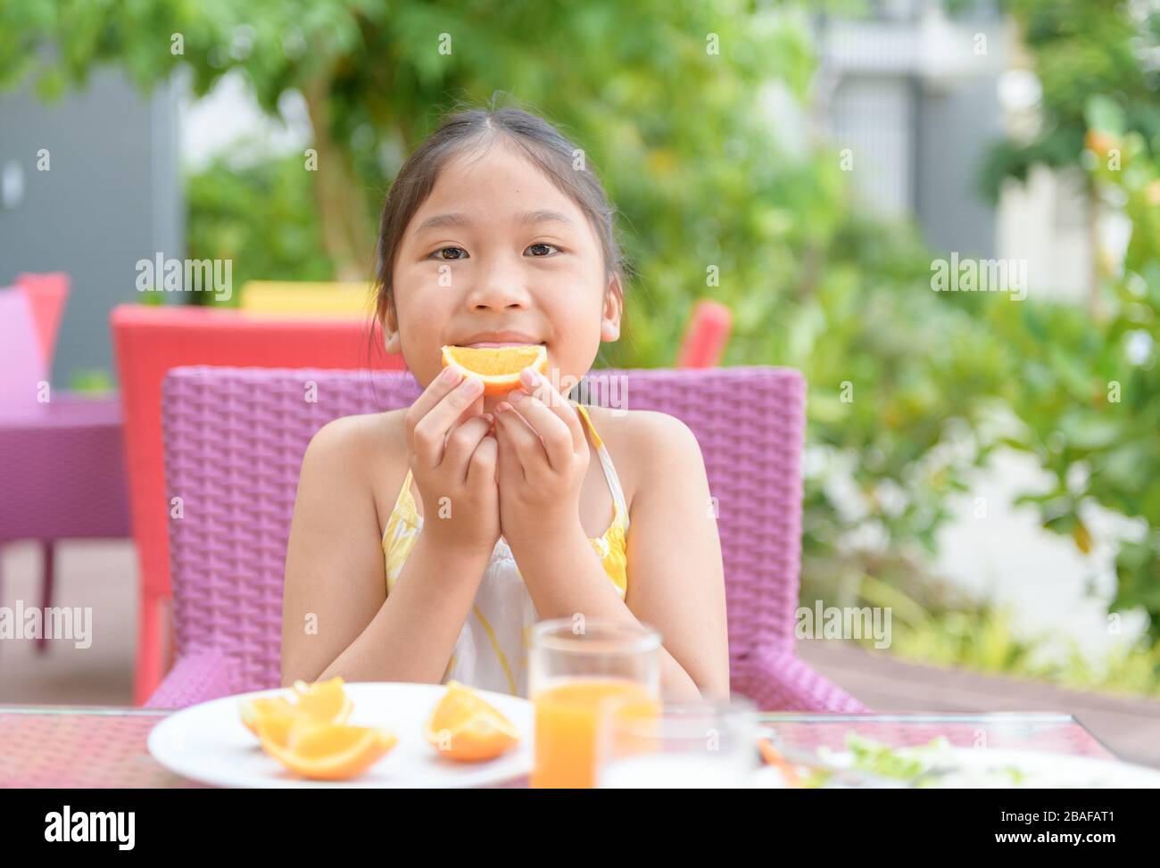 Cute asian girl enjoy to eat fresh orange on morning, Healthy concept ...