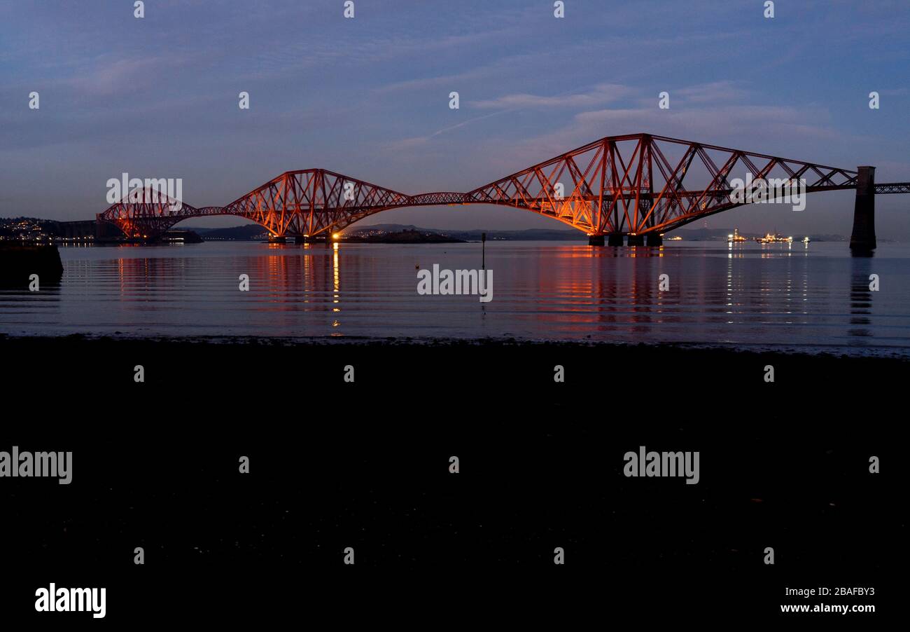 Lighted Forth railway bridge across the Firth viewed from South Queensferry by night in winter, Scotland, UK, Europe Stock Photo