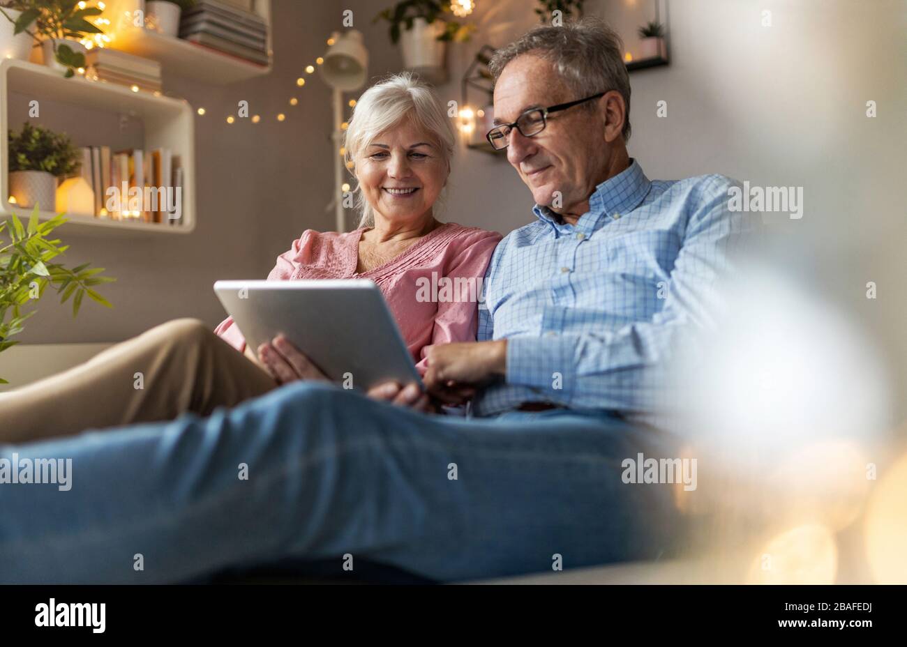 Mature couple using a laptop while relaxing at home Stock Photo