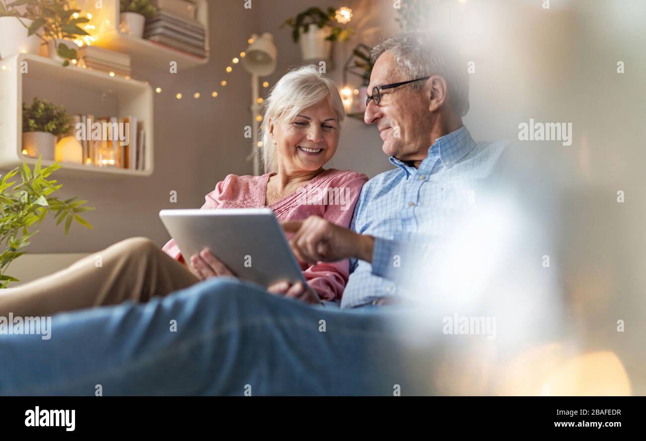Mature couple using a laptop while relaxing at home Stock Photo