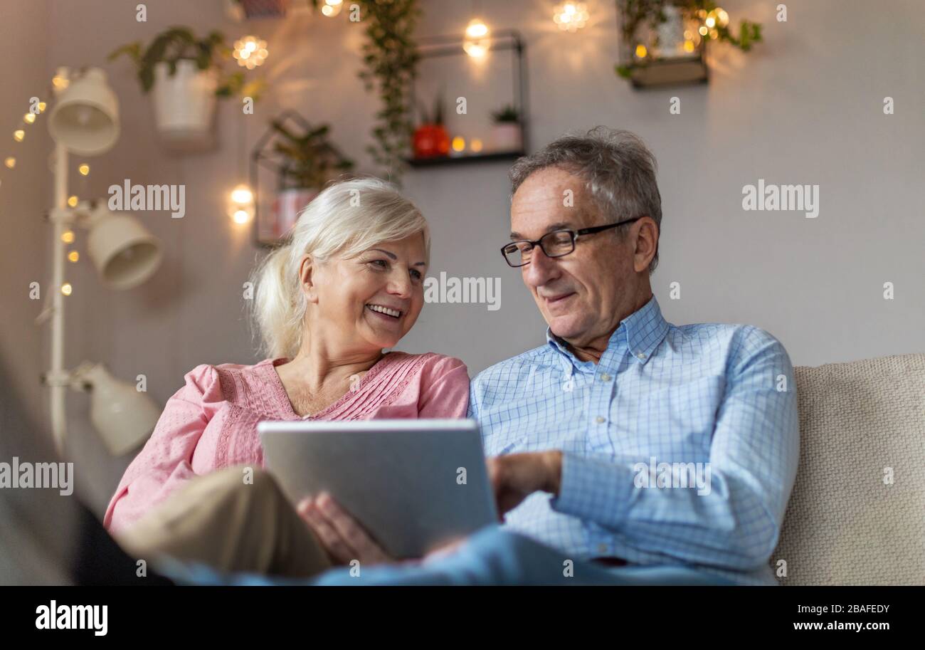 Mature couple using a laptop while relaxing at home Stock Photo