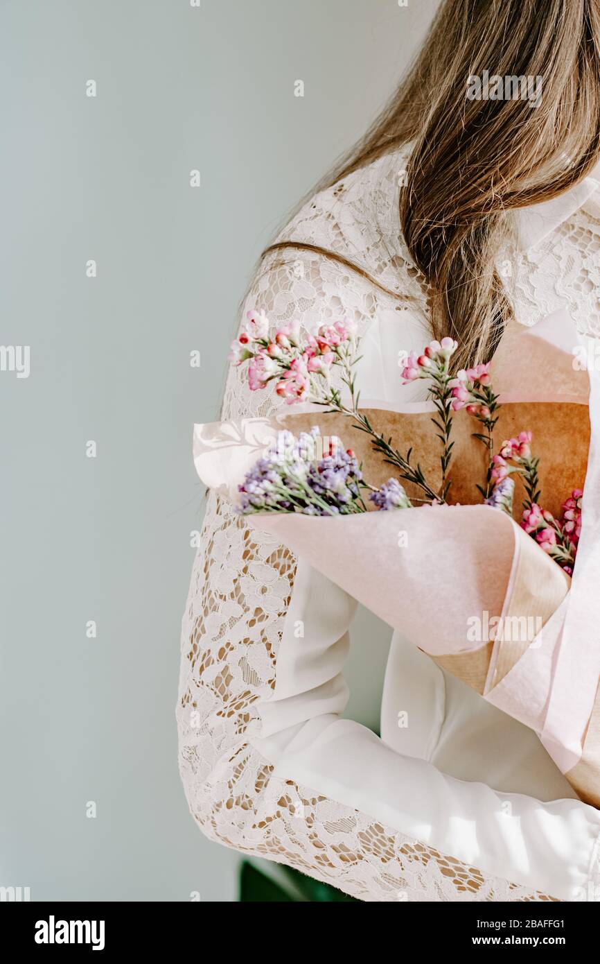 Woman wearning lace blouse holding bunch of flowers, mothers day gift, delicate women concept, beauty, feminine concept, model, modelling, pretty Stock Photo