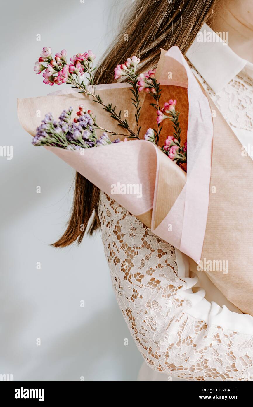 Woman wearning lace blouse holding bunch of flowers, mothers day gift, delicate women concept, beauty, feminine concept, model, modelling, pretty Stock Photo