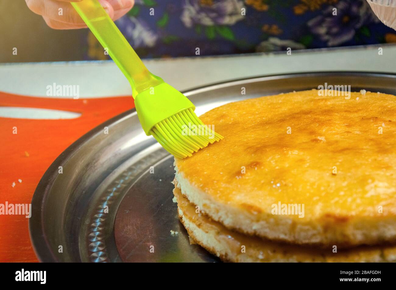 Baking Ingredients and Utensils for Cooking Sponge Cake. Process Cooking Sponge Cake. Woman Impregnates Syrup Cakes. Stock Photo