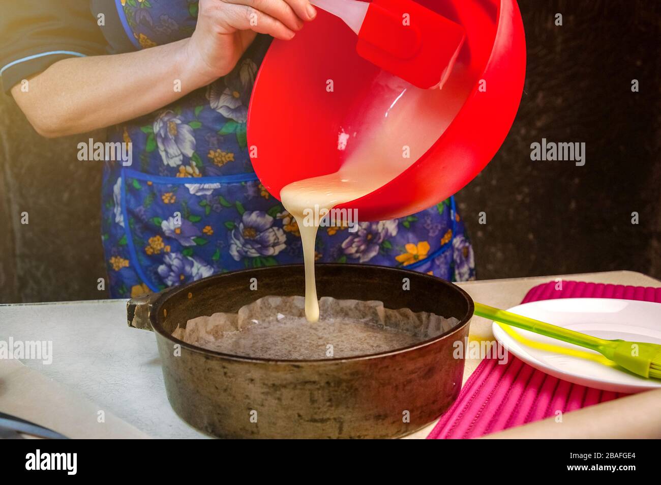 Baking Ingredients and Utensils for Cooking Sponge Cake. Process Cooking Sponge Cake. Woman Pours the Dough into a Baking Mold. Stock Photo