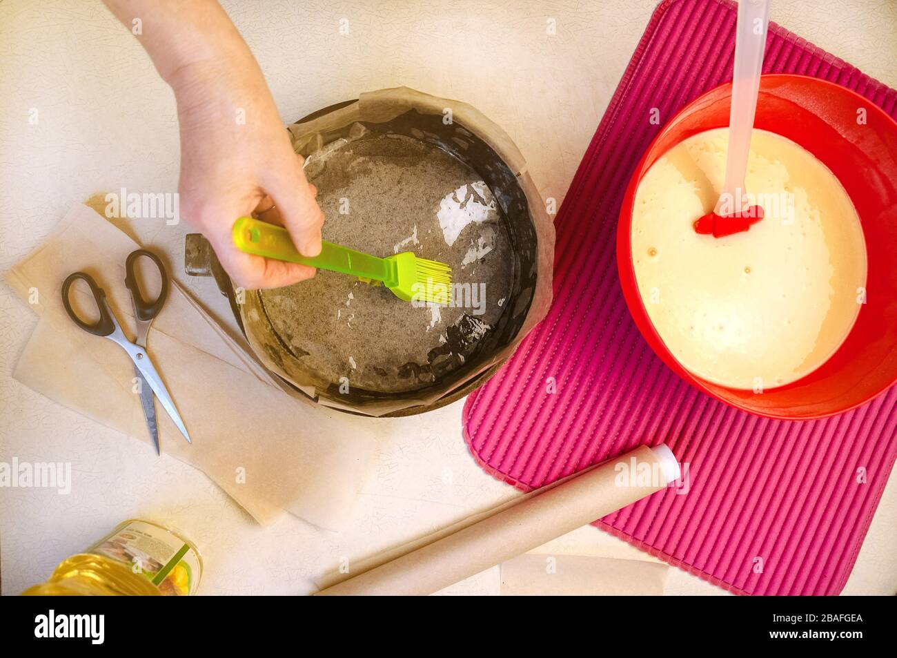Baking Ingredients and Utensils for Cooking Sponge Cake. Process Cooking Sponge Cake. Woman Lubricates Oil the Baking Dish. Flat Lay Top View. Stock Photo