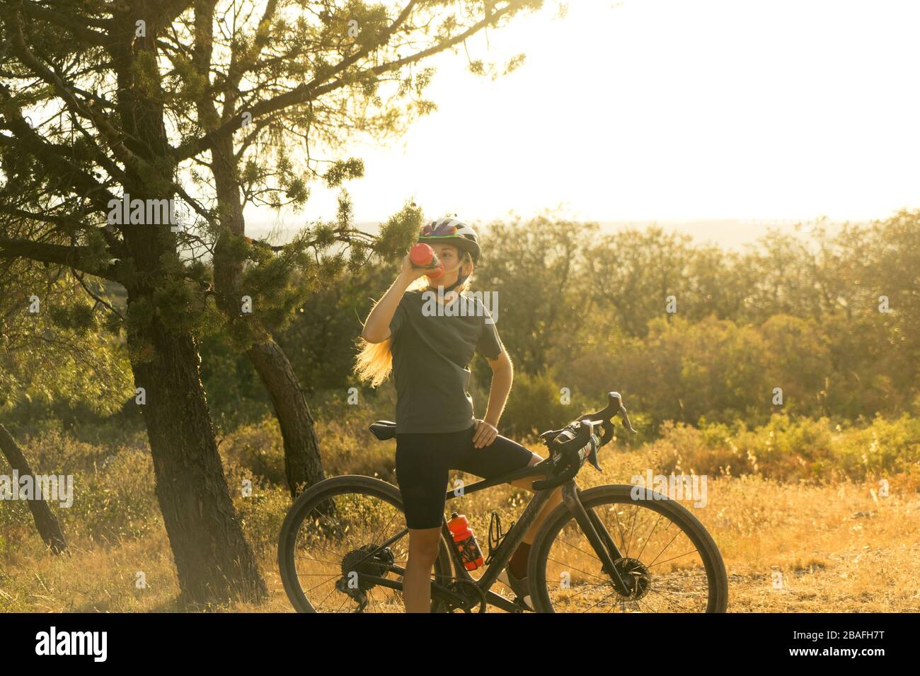 Beautiful athlete cyclist stops for water drinking Stock Photo Alamy