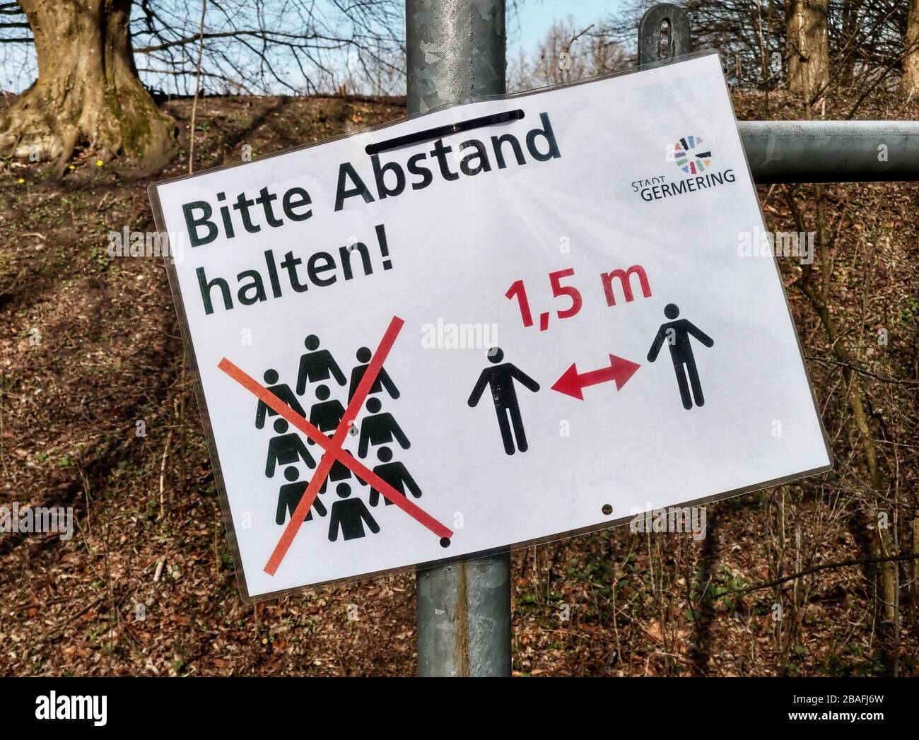 March 27, 2020, Munich, Bavaria, Germany: A sign newr Munich, Germany indicating the minimum distance required between people that may pass by one another.  Due to strict infection control regulations and police enforcement, a maximum of two people from the same household are allowed together in public or private spaces and a minimum of 1.5m apart for people one may pass by. (Credit Image: © Sachelle Babbar/ZUMA Wire) Stock Photo