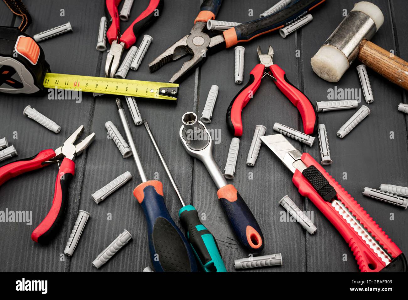 Pliers, screwdrivers, cutter, ratchet wrench, hammer, meter and dowels