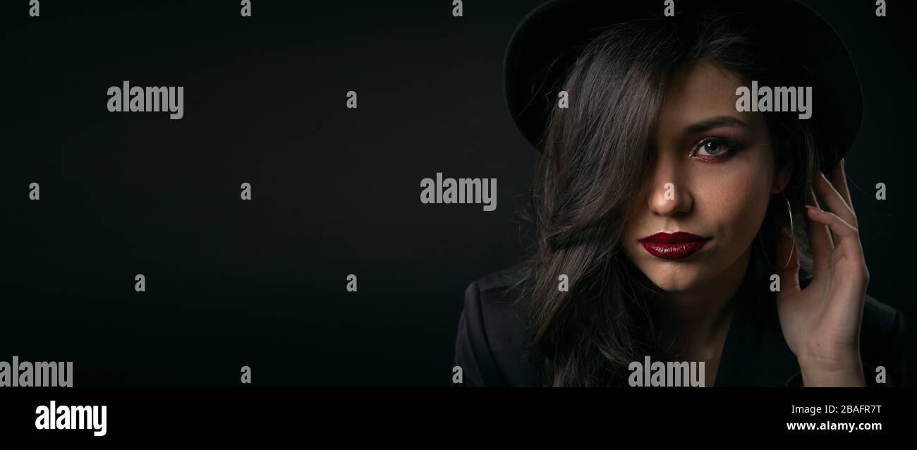 Charming young lady touching hat Stock Photo