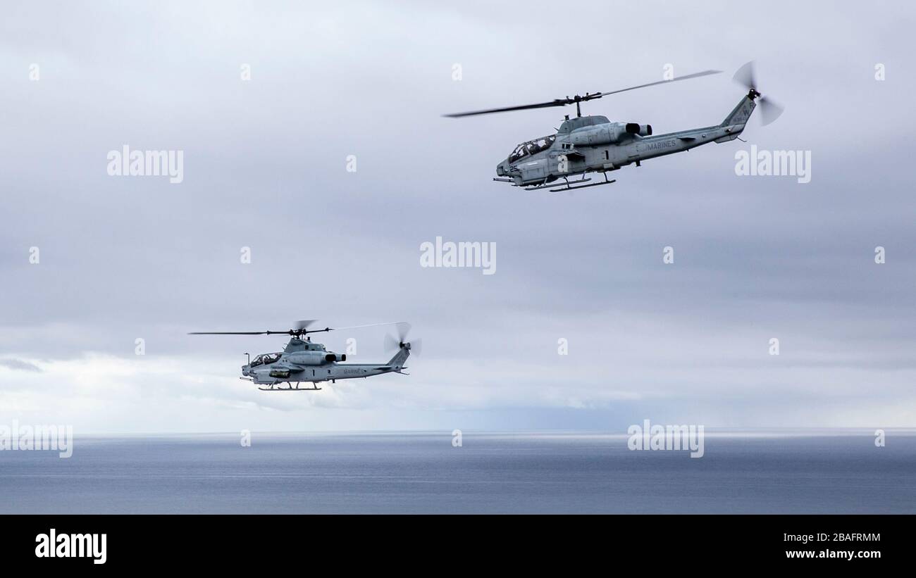 A U.S. Marine AH-1W Super Cobra and AH-1Z Viper helicopter with Marine Light Attack Helicopter Squadron 775, fly in formation along the Southern California coast March 14, 2020 near Pendleton, California. Stock Photo