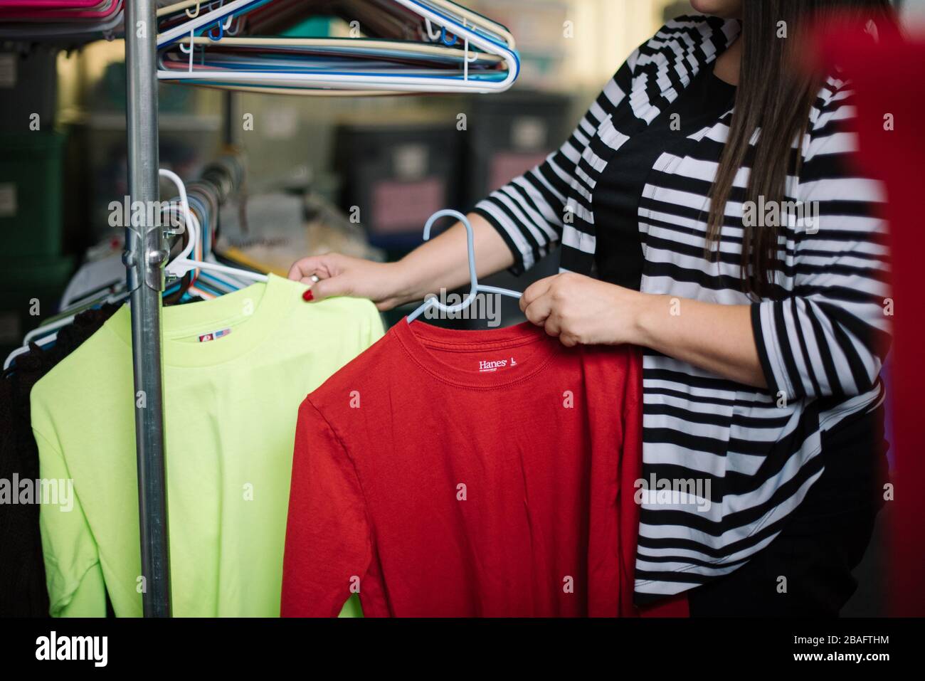 woman's hands sorting clothing donation at a homeless shelter Stock