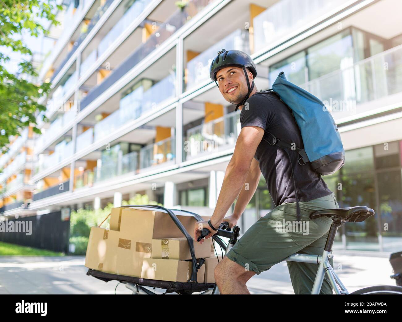 Bicycle messenger making a delivery on a cargo bike Stock Photo Alamy