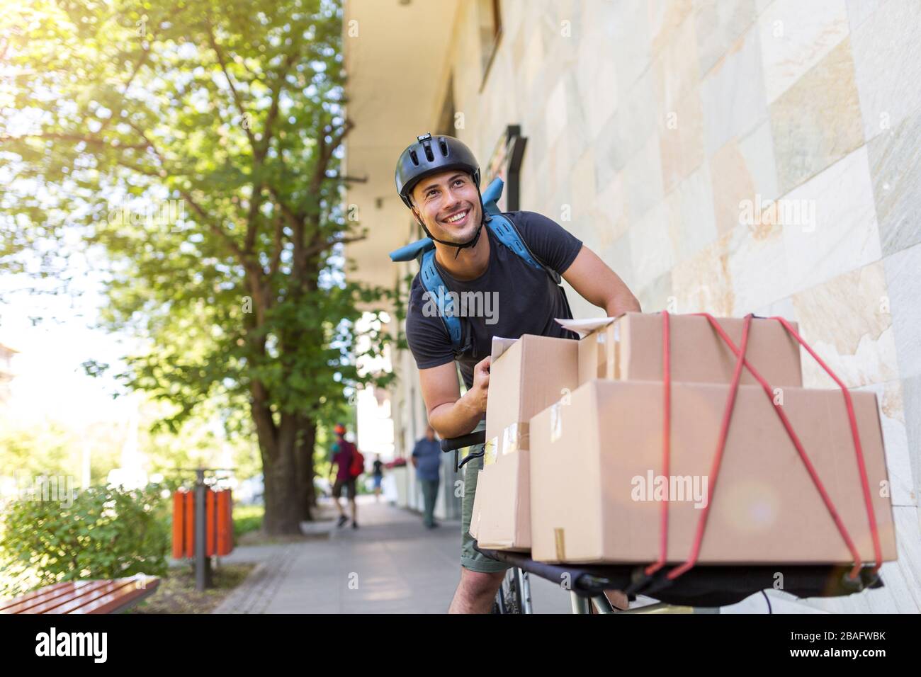 Bicycle messenger making a delivery on a cargo bike Stock Photo Alamy