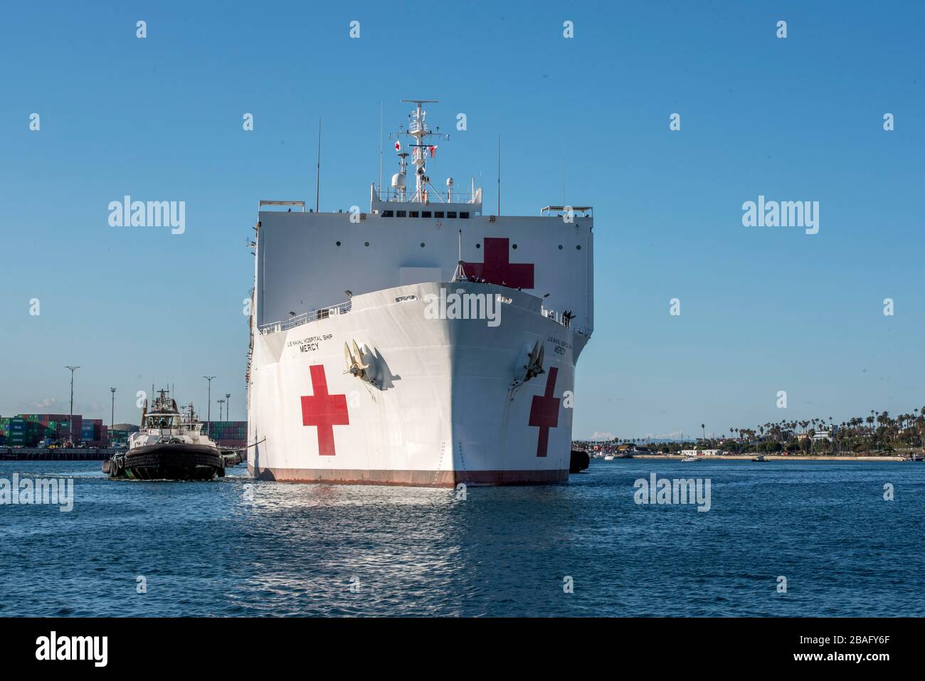 In this photo released by the United States Navy, the Military Sealift Command hospital ship USNS Mercy (T-AH 19) arrives in Los Angeles, California, March 27, 2020. Mercy deployed in support of the nation's COVID-19 response efforts, and will serve as a referral hospital for non-COVID-19 patients currently admitted to shore-based hospitals. This allows shore base hospitals to focus their efforts on COVID-19 cases. One of the Department of Defense's missions is Defense Support of Civil Authorities. DoD is supporting the Federal Emergency Management Agency, the lead federal agency, as well as s Stock Photo