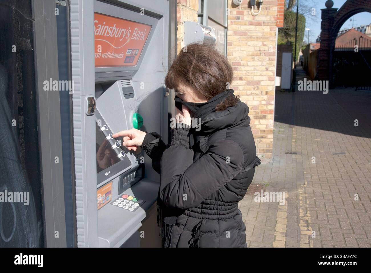 middle aged woman during coronavirus 2020 at ATM Stock Photo
