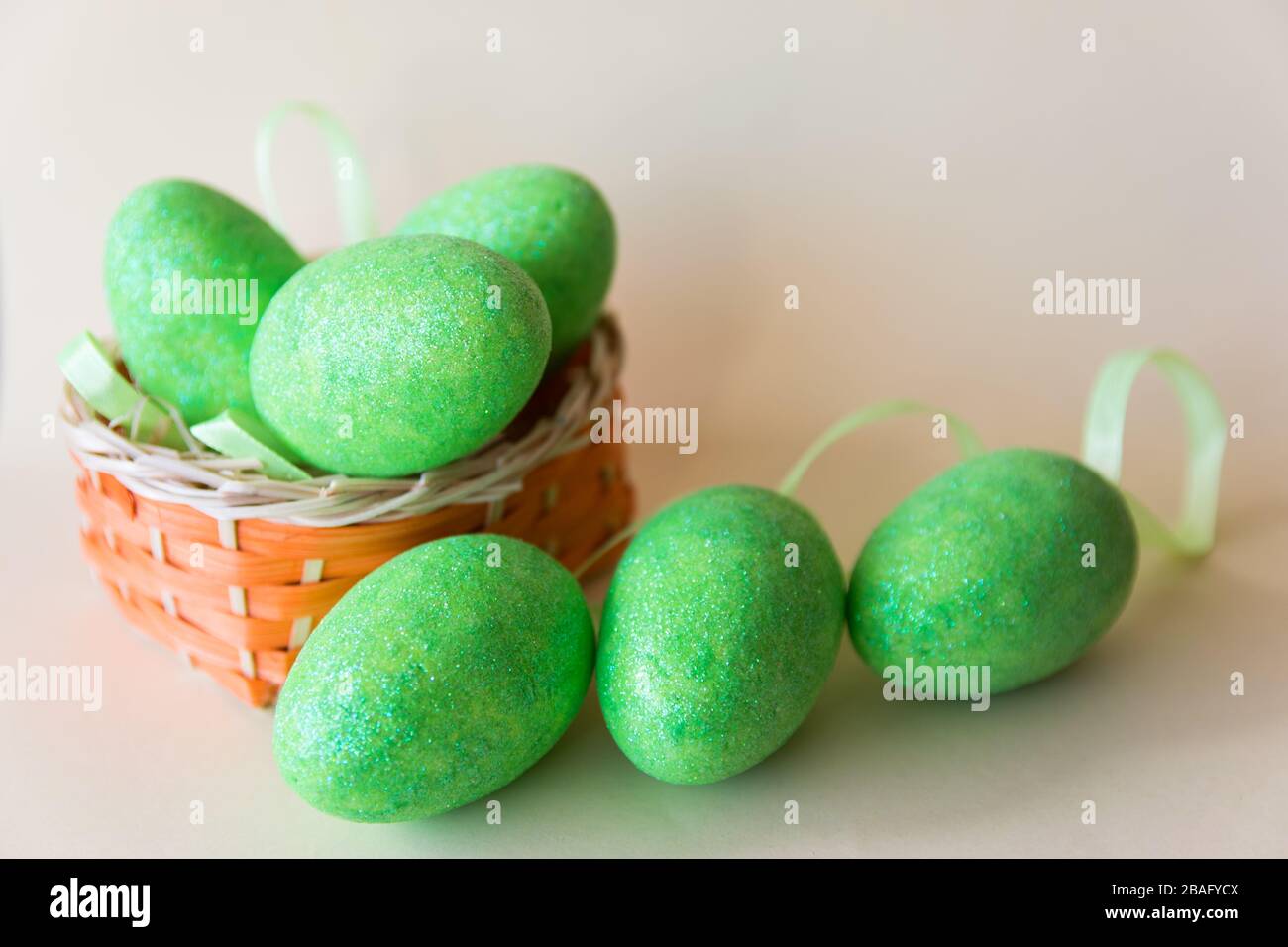 Easter green eggs in the basket on beige background. Easter concept. Spring time. Stock Photo