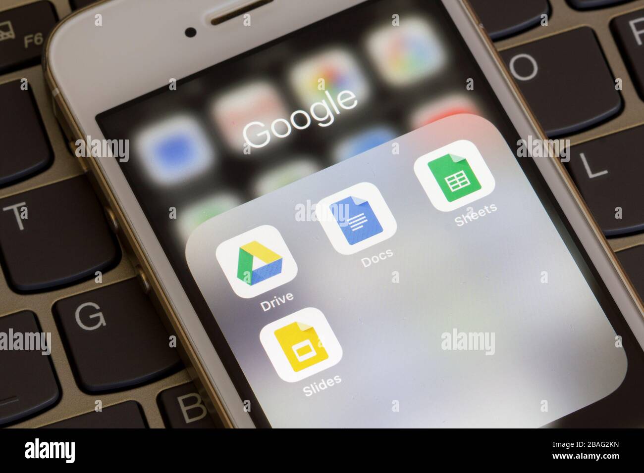 Mobile app icons of Google Drive Enterprise suite with Google Docs, Sheets, and Slides are seen on a smartphone. Stock Photo