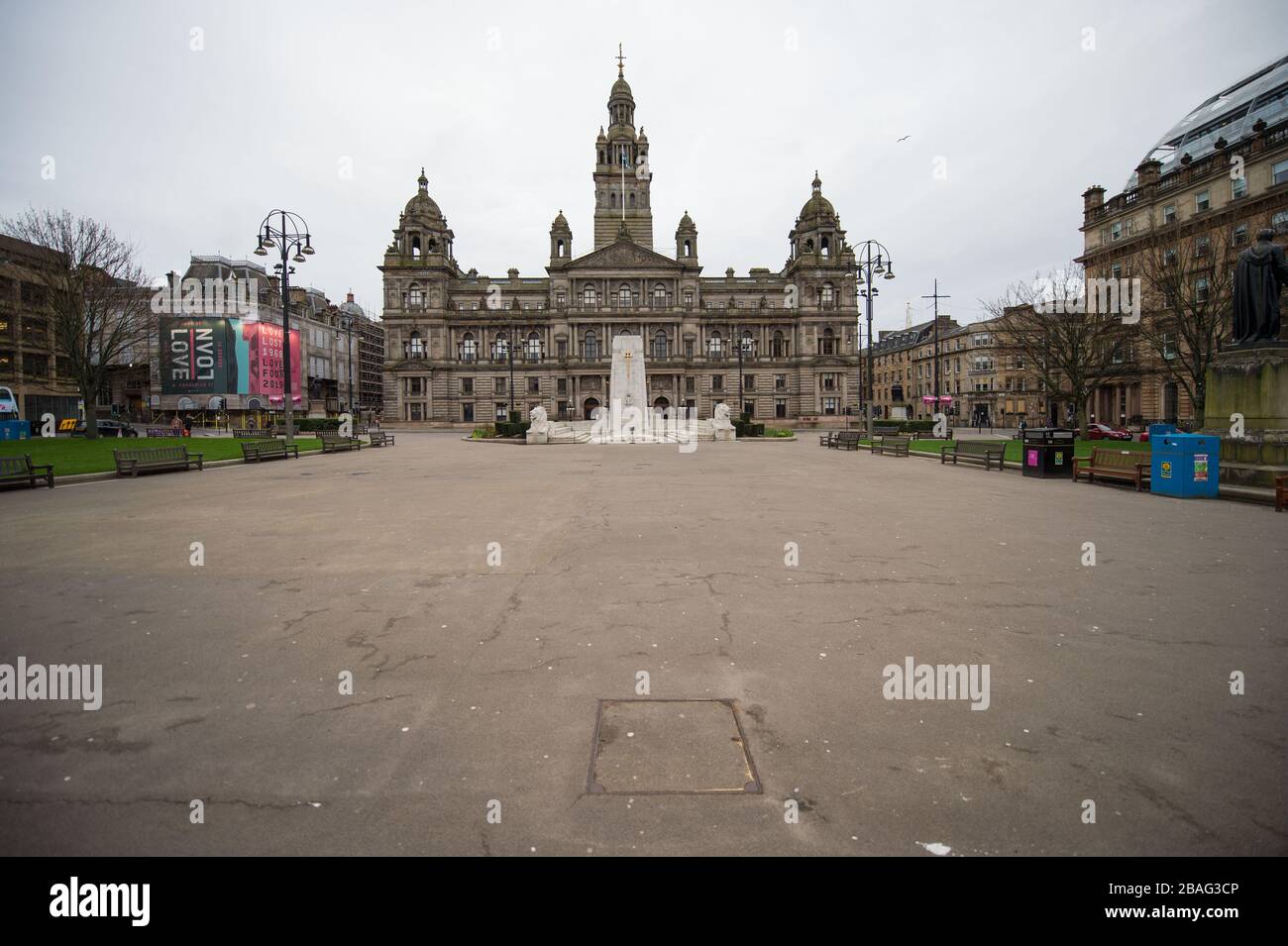 Glasgow, UK. 27th Mar, 2020. Pictured: George Square in the centre of Glasgow showing the City Chambers is now completely empty. Views of Glasgow City Centre showing empty streets, shops closed and empty railway stations during what would normally be a busy street scene with shoppers and people working within the city. The Coronavirus Pandemic has forced the UK Government to order a shut down of all the UK major cities and make people stay at home. Credit: Colin Fisher/Alamy Live News Stock Photo