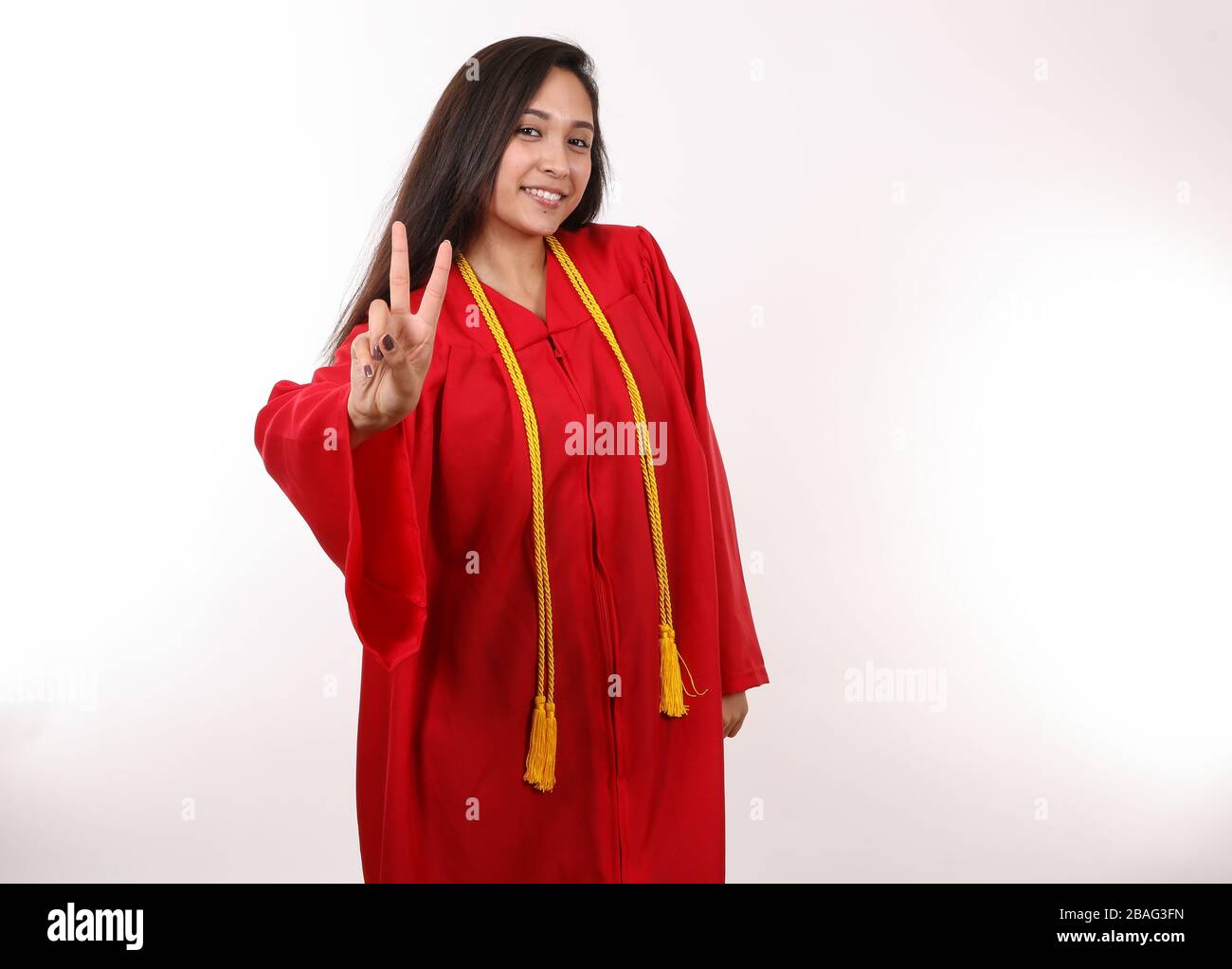A graduating student holds up a peace sign. Stock Photo