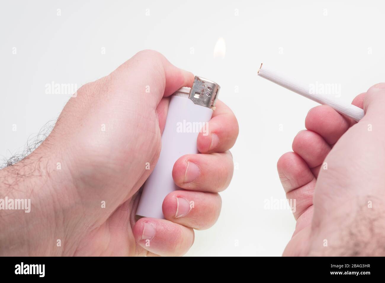 Man lights a cigarette isolated on white Stock Photo