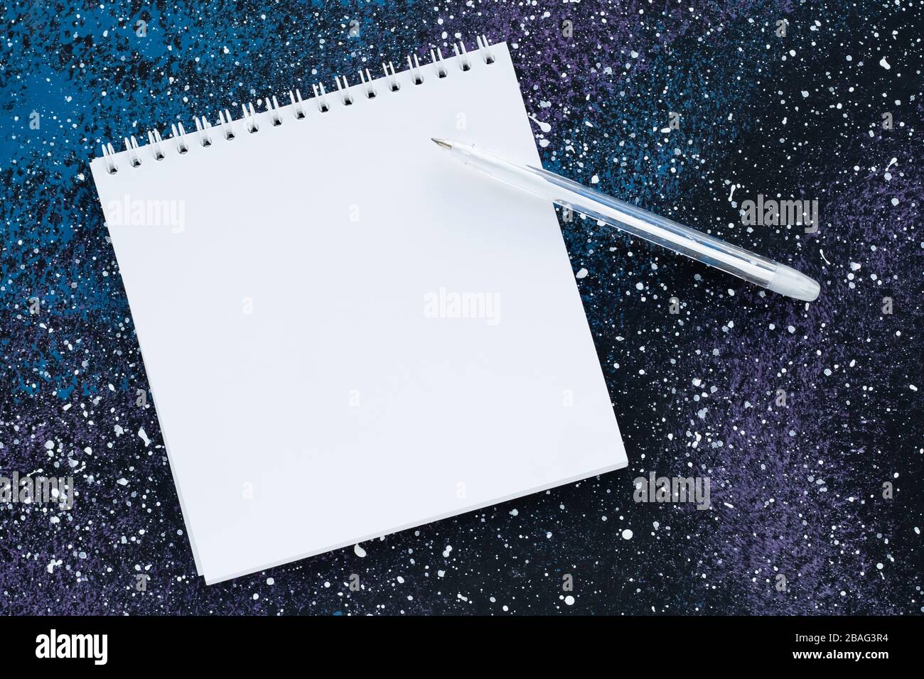 Blank spiral notebook with copy space for text on abstract dark blue background. Planning concept. White paper page and pen, empty sheet, mockup Stock Photo