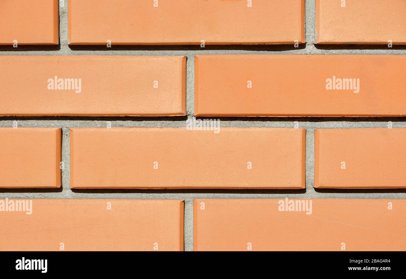 Texture of the wall of a new red brick house lit by the sun. Background Stock Photo