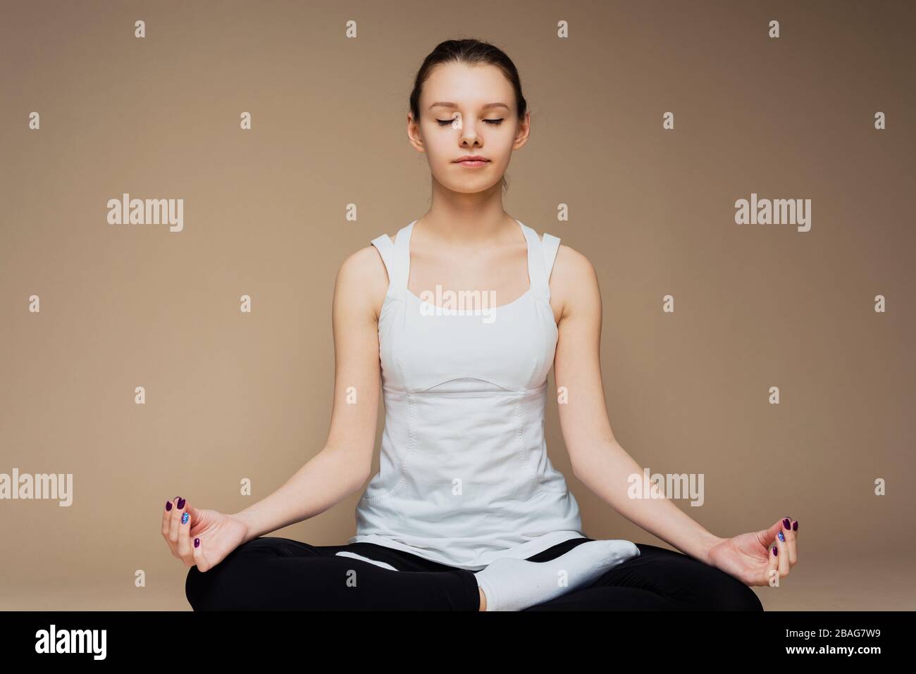 A girl sits in a lotus position and meditates with her eyes closed. Zen ...