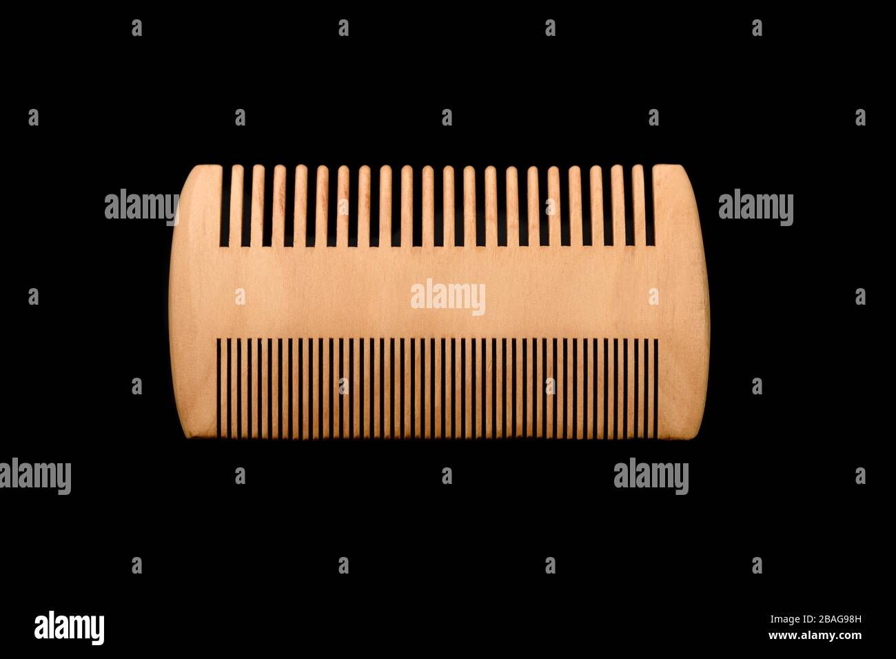 Wooden beard comb isolated on black background. Stock Photo