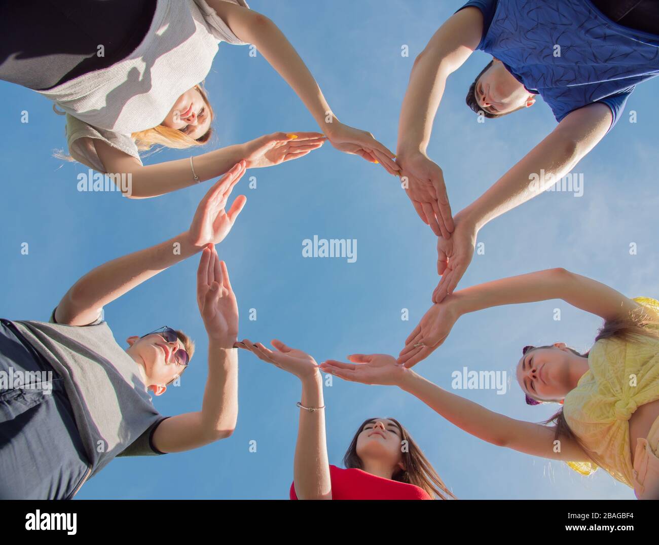 A group of friends makes a circle from the palms of their hands Stock Photo
