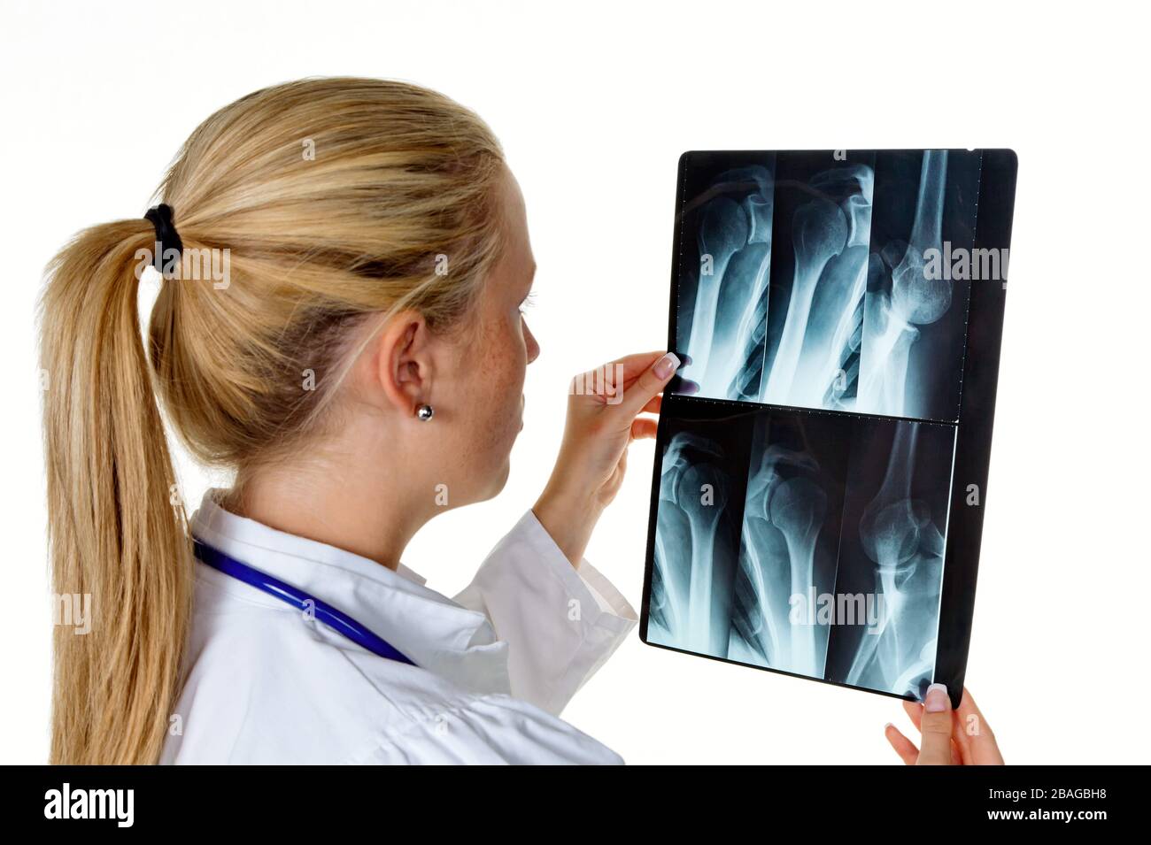 Eine junge Aerztin mit Stethoskop betrachtet ein Roentgenbild, MR: YES Stock Photo