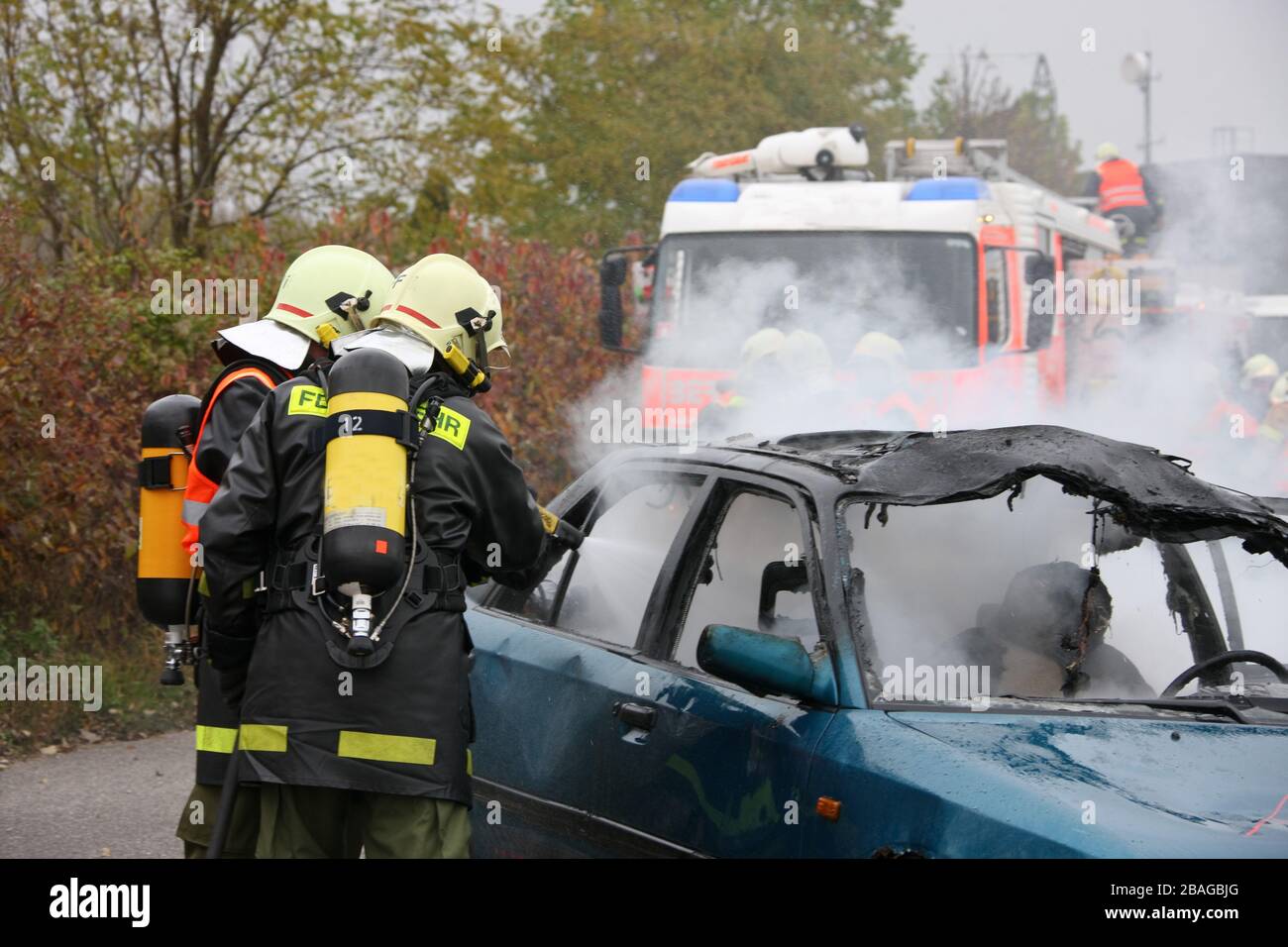 Feuerwehr loescht ein brennendes Auto, Verkehrsunfall, Stock Photo