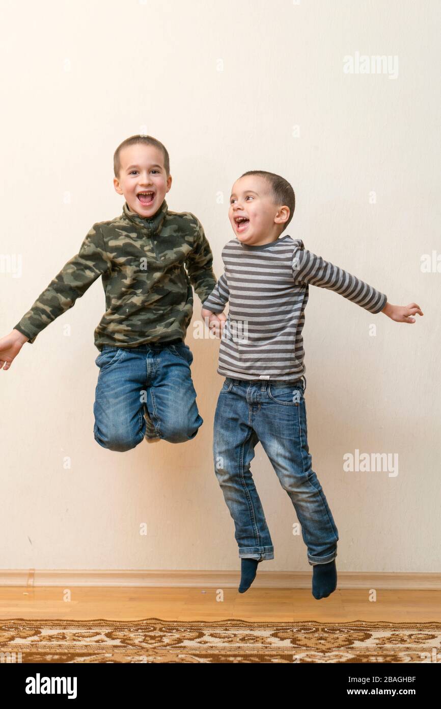 Two boys are playing in the house. children brothers playing together at home. jumping children ...