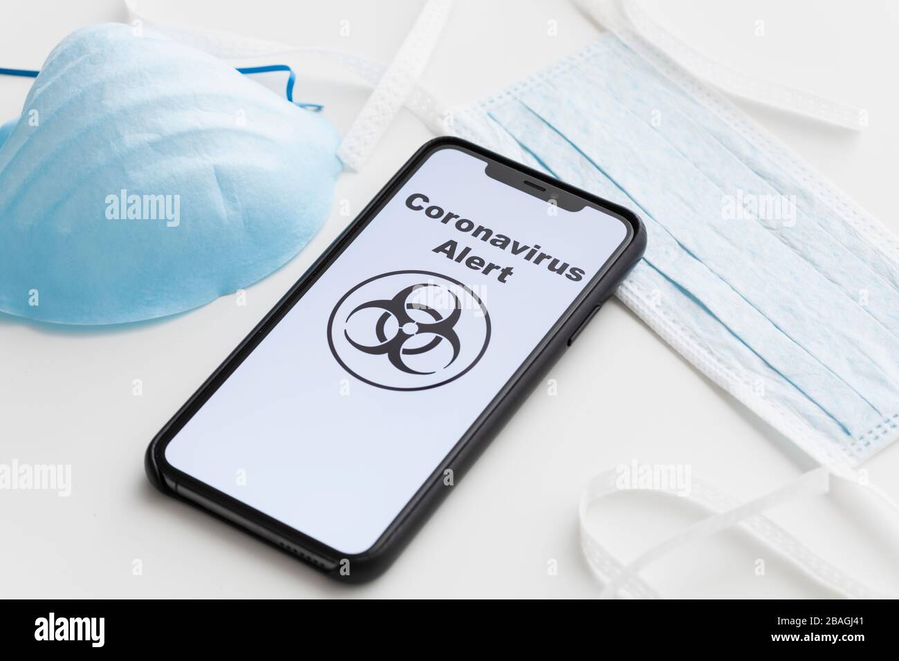 Coronavirus alert on cell phone with surgical masks Stock Photo