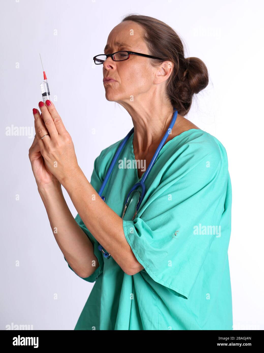 August 2015 - Older lady doctor returning to duty to serve too assist with the treatment of Coronavirus patients Stock Photo