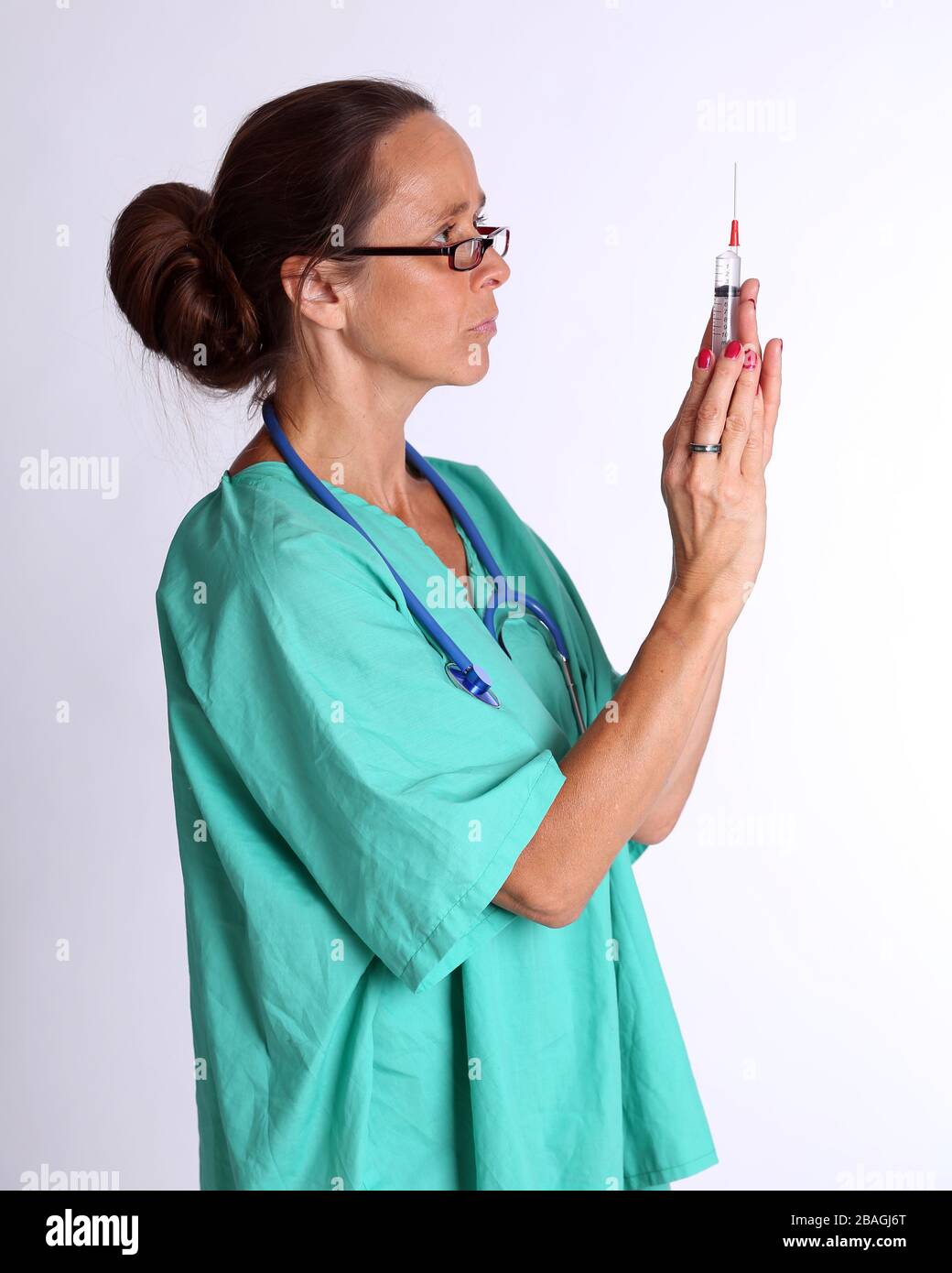 August 2015 - Older lady doctor returning to duty to serve too assist with the treatment of Coronavirus patients Stock Photo