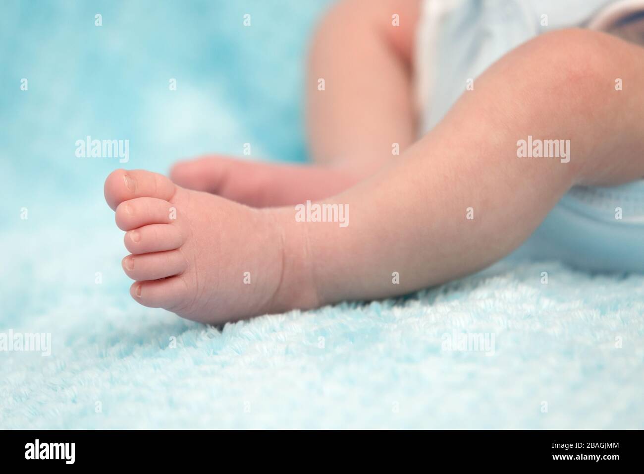 Adorable Little Baby Feet Closeup on Soft Blue Background Stock Photo