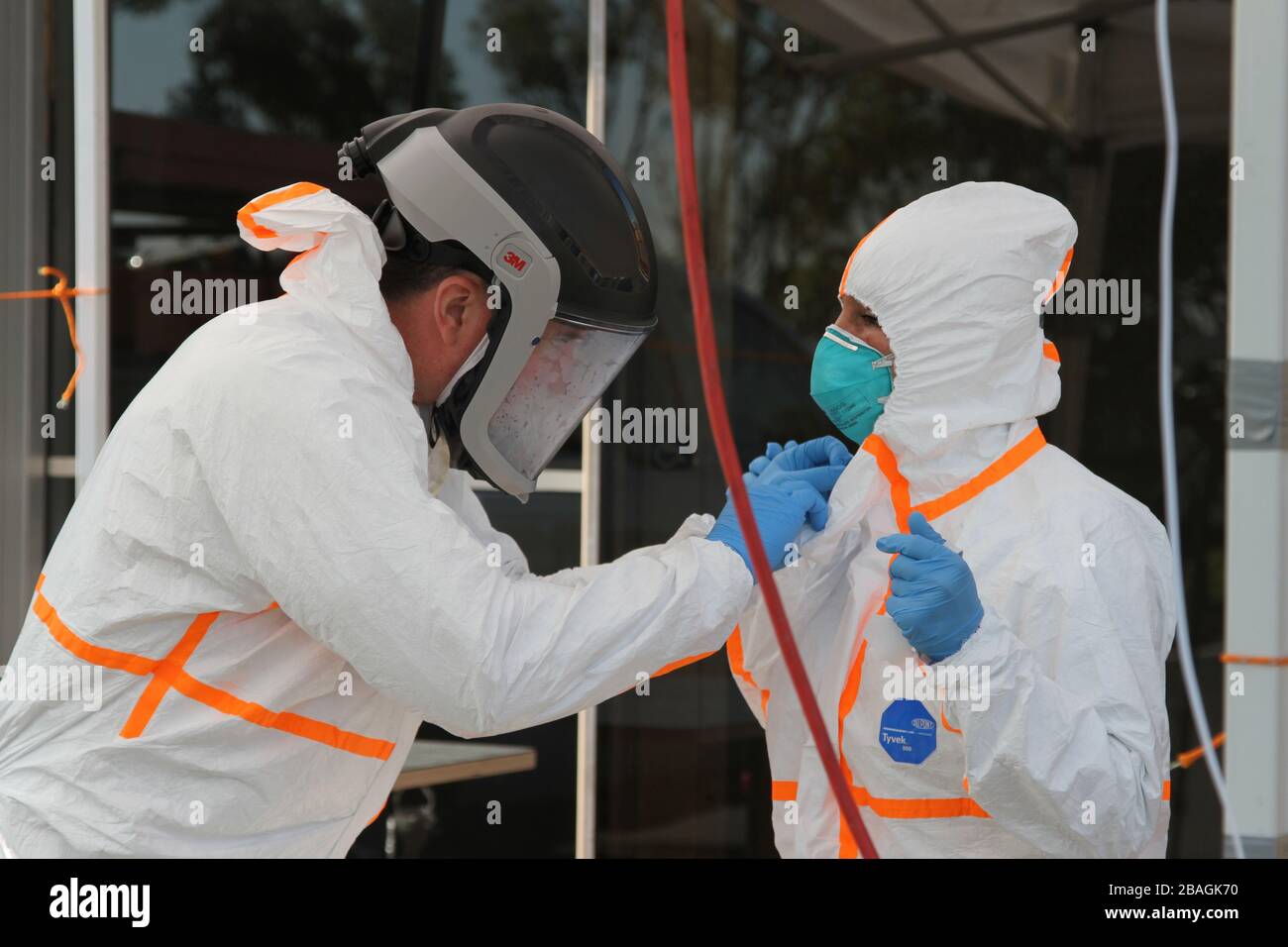 San Mateo, United States. 27th Mar, 2020. A California State Guard member and a California Emergency Medical Service Authority staff member suit up with personal protective equipment before assisting with treating COVID-19 patients March 27, 2020 in San Mateo County, California. Credit: Eddie Siguenza/US Army/Alamy Live News Stock Photo