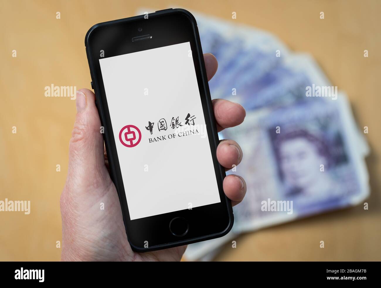 A woman looking at the Bank of China logo on a mobile phone. (editorial Use Only) Stock Photo