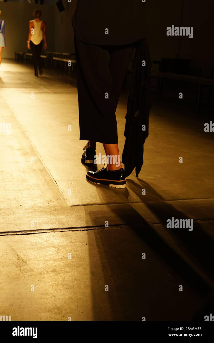 Backstage on the catwalk wearing patent black platform shoes. Stock Photo